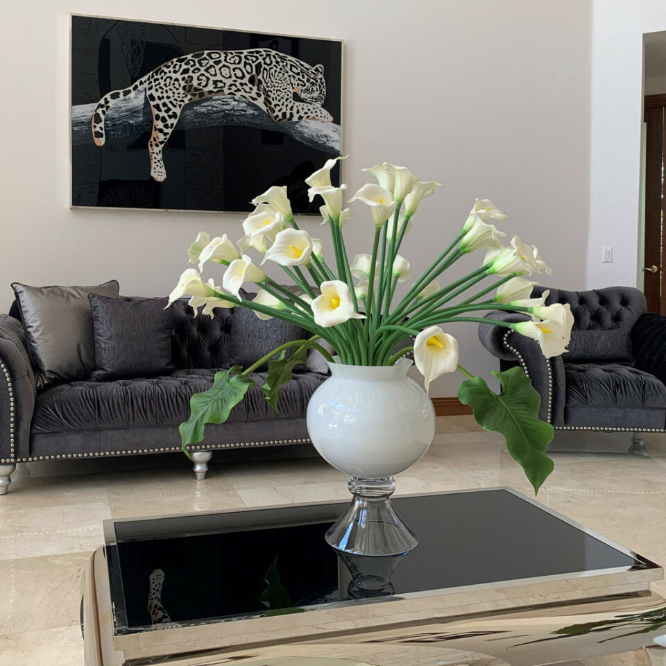 Vase élégant avec plusieurs lys calla blancs.