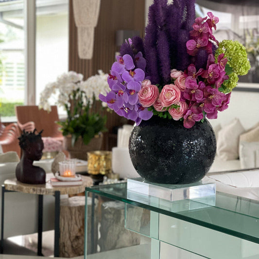 Vase en mosaïque noire avec liatris et orchidées
